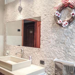Bagno con rivestimento e lavabo in pietra